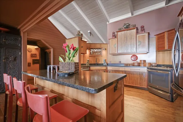 a kitchen with kitchen island granite countertop a sink cabinets and stainless steel appliances