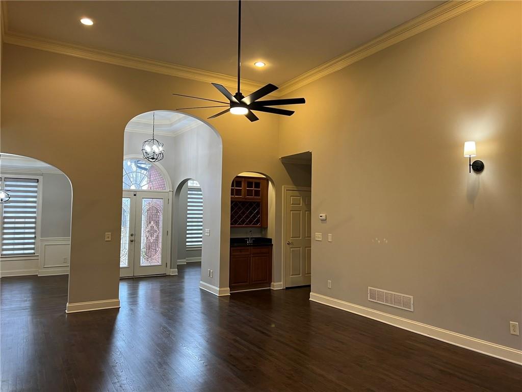 2476 Sewell Mill Road Marietta, GA 30062 - Photo 9 of 43 an empty room with wooden floor chandelier fan and windows