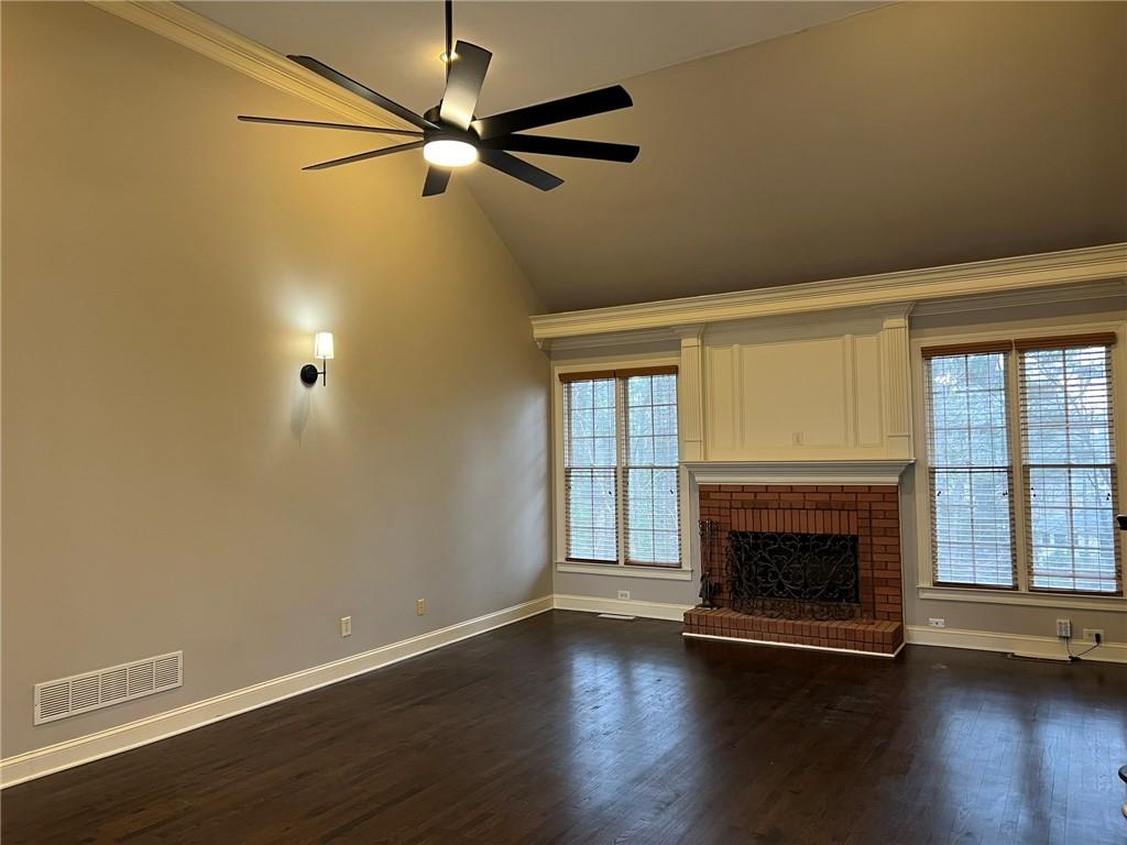 2476 Sewell Mill Road Marietta, GA 30062 - Photo 10 of 43 an empty room with wooden floor fireplace and windows