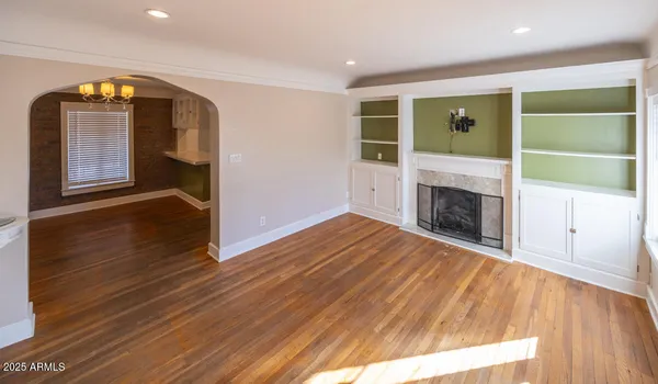 a view of empty room with wooden floor and fireplace