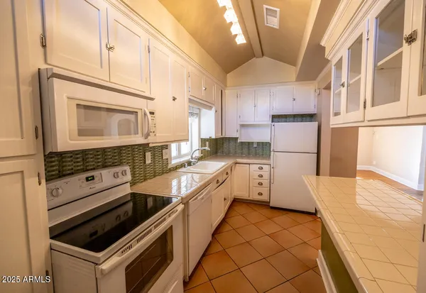 a kitchen that has a sink a stove and a microwave