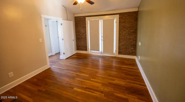 an empty room with wooden floor and entrance