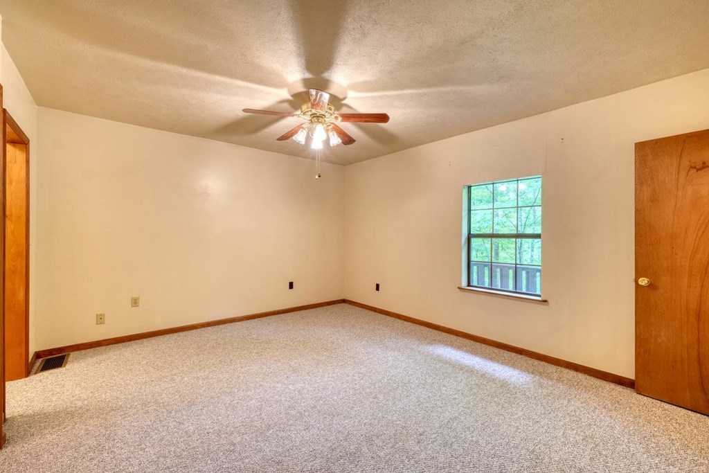 1066 Ridge Road Hiawassee, GA 30546 - Photo 31 of 51 an empty room with chandelier fan and windows