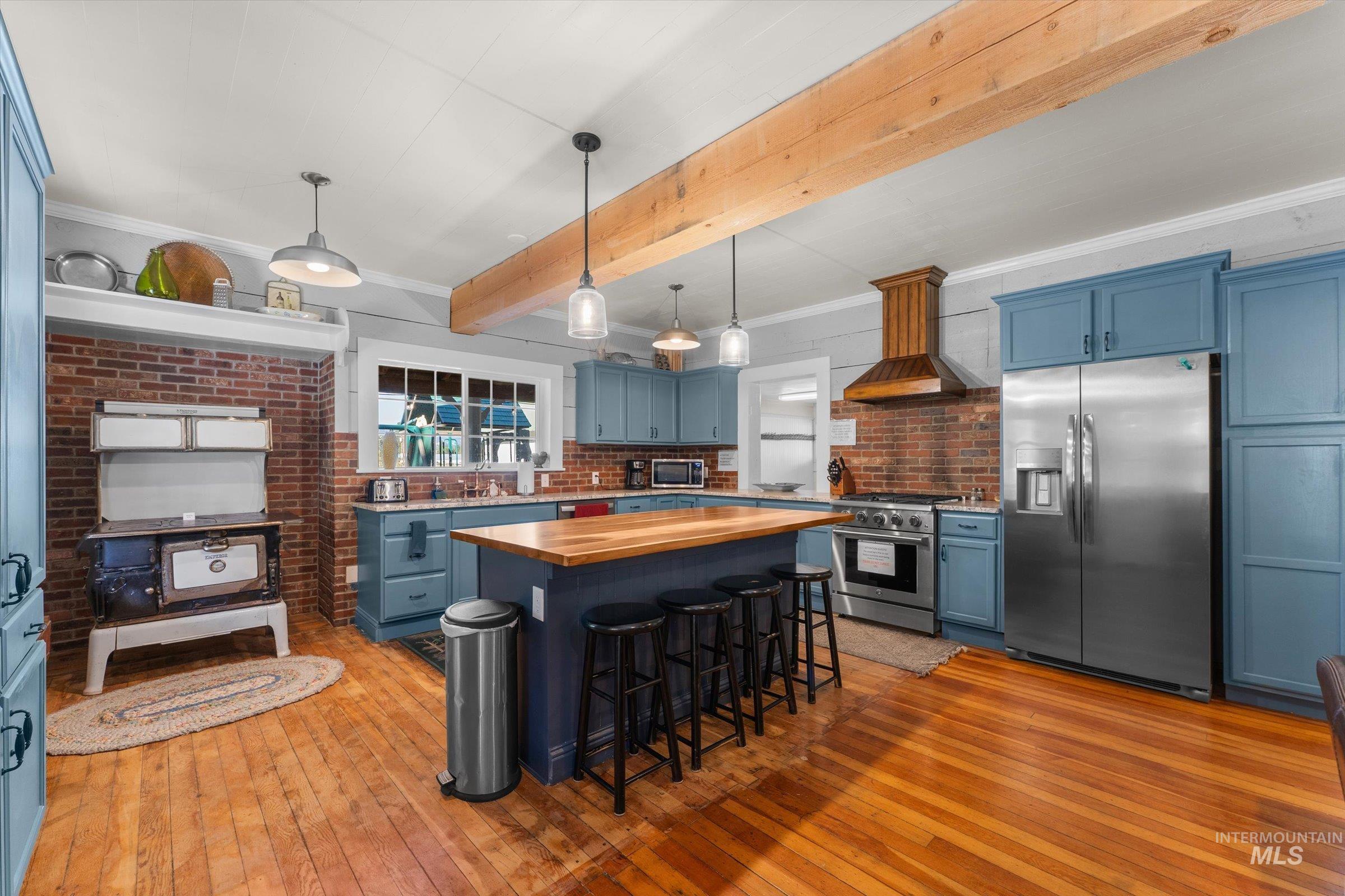 315 South Middlefork Road Garden Valley, ID 83622 - Photo 7 of 49 Kitchen with blue cabinets, wood counters, appliances with stainless steel finishes, ornamental molding, and decorative light fixtures