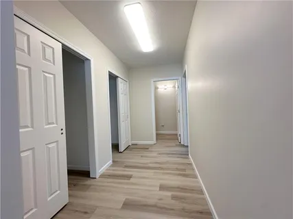 a view of a hallway with wooden floor and entryway