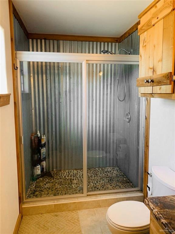 2938 Highway 83 Roma, TX 78584 - Photo 14 of 23 Full bath with a stall shower, tile patterned flooring, and vanity