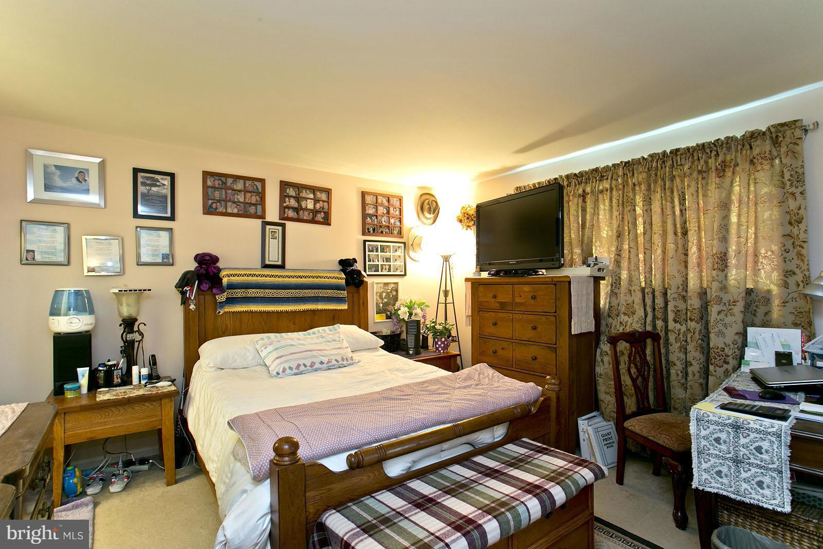 611 Veterans Road Middletown, VA 22645 - Photo 5 of 14 a bedroom with a bed a dresser and a flat screen tv