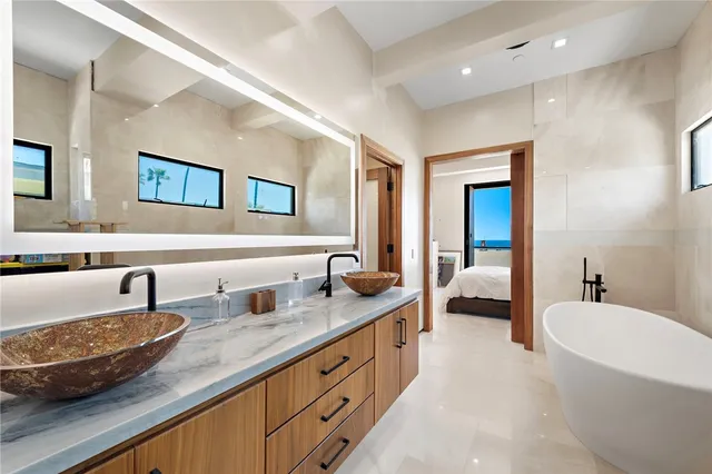 a spacious bathroom with a tub double sink and glass door