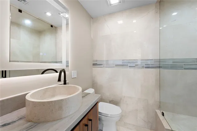 a bathroom with a sink a toilet and a mirror