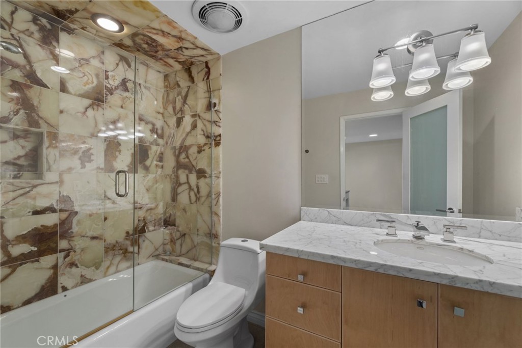 4 Jib Street, Unit 3 Marina del Rey, CA 90292 - Photo 32 of 37 a bathroom with a granite countertop sink a toilet a mirror a bathtub and shower