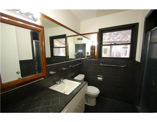 214 Doddridge Street Corpus Christi, TX 78411 - Photo 6 of 9 a bathroom with a toilet a sink a mirror a window and vanity