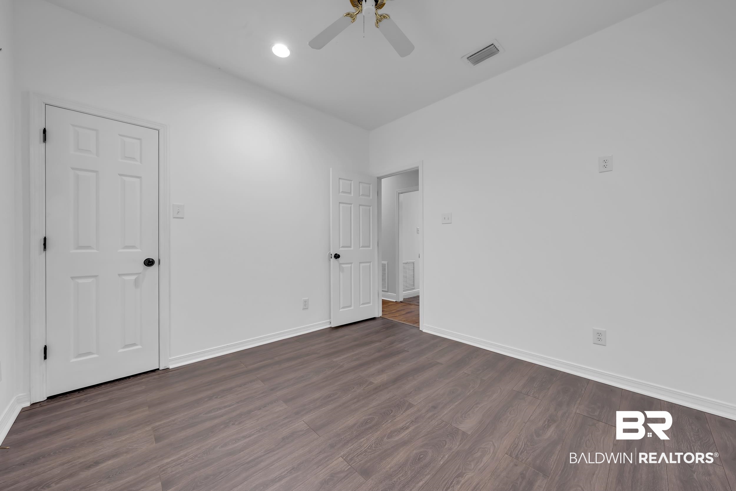 14960 Howells Ferry Road Wilmer, AL 36587 - Photo 16 of 22 Spacious room featuring wood-finish flooring, white baseboards, and white walls