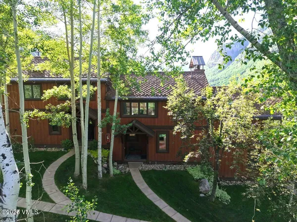 a view of a house with a tree in front of it