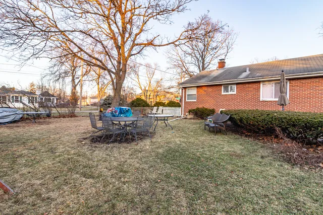 a backyard of a house with table and chairs