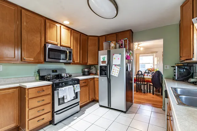 a kitchen with stainless steel appliances granite countertop a refrigerator stove top oven a sink and dishwasher
