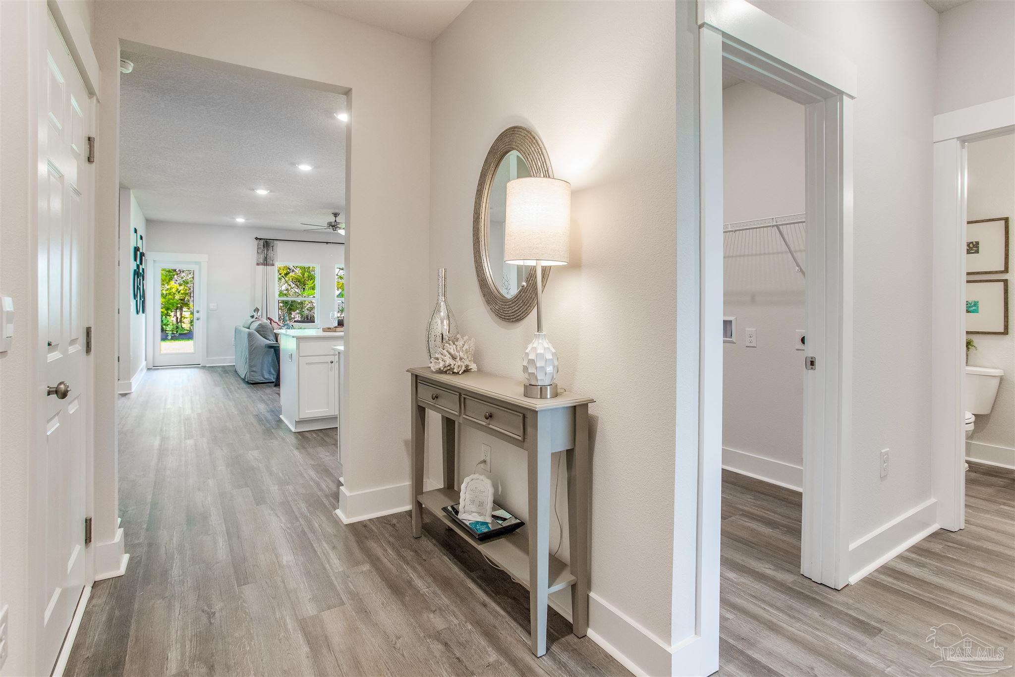 3459 Crossvine Road Cantonment, FL 32533 - Photo 28 of 38 a view of a hallway with wooden floor windows and a bathroom