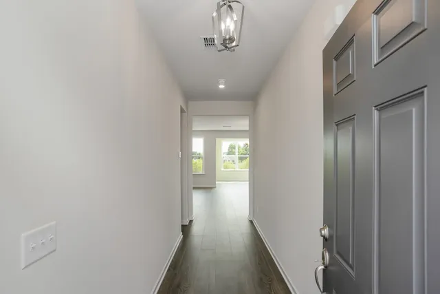 a view of a hallway with wooden floor and closet