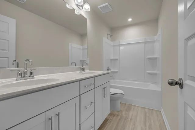 a bathroom with a sink a toilet a shower and a mirror