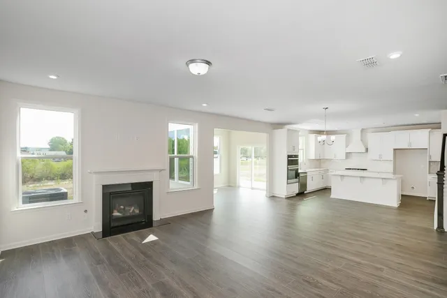 a view of a livingroom with furniture a fireplace and wooden floor