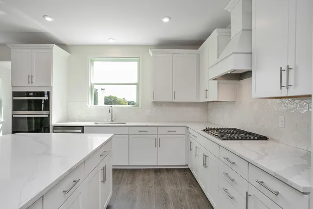 a kitchen with cabinets appliances a sink and a window