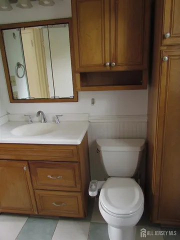 a bathroom with a toilet a sink and a mirror