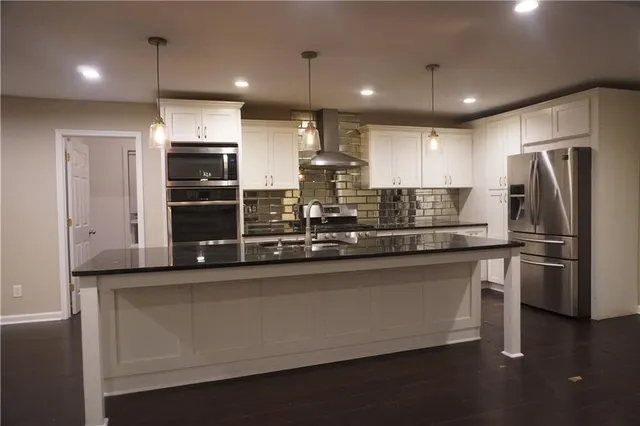 a kitchen with stainless steel appliances granite countertop a refrigerator and a sink