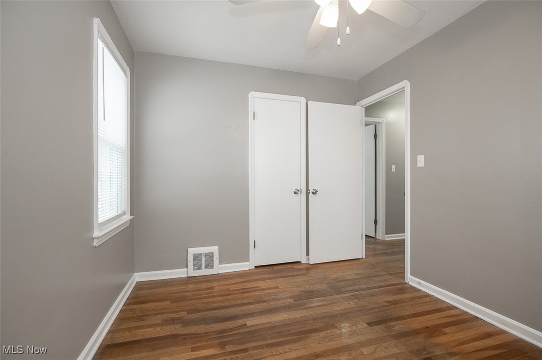 12328 Granger Road Cleveland, OH 44125 - Photo 15 of 37 Unfurnished bedroom featuring dark wood-style flooring and ceiling fan
