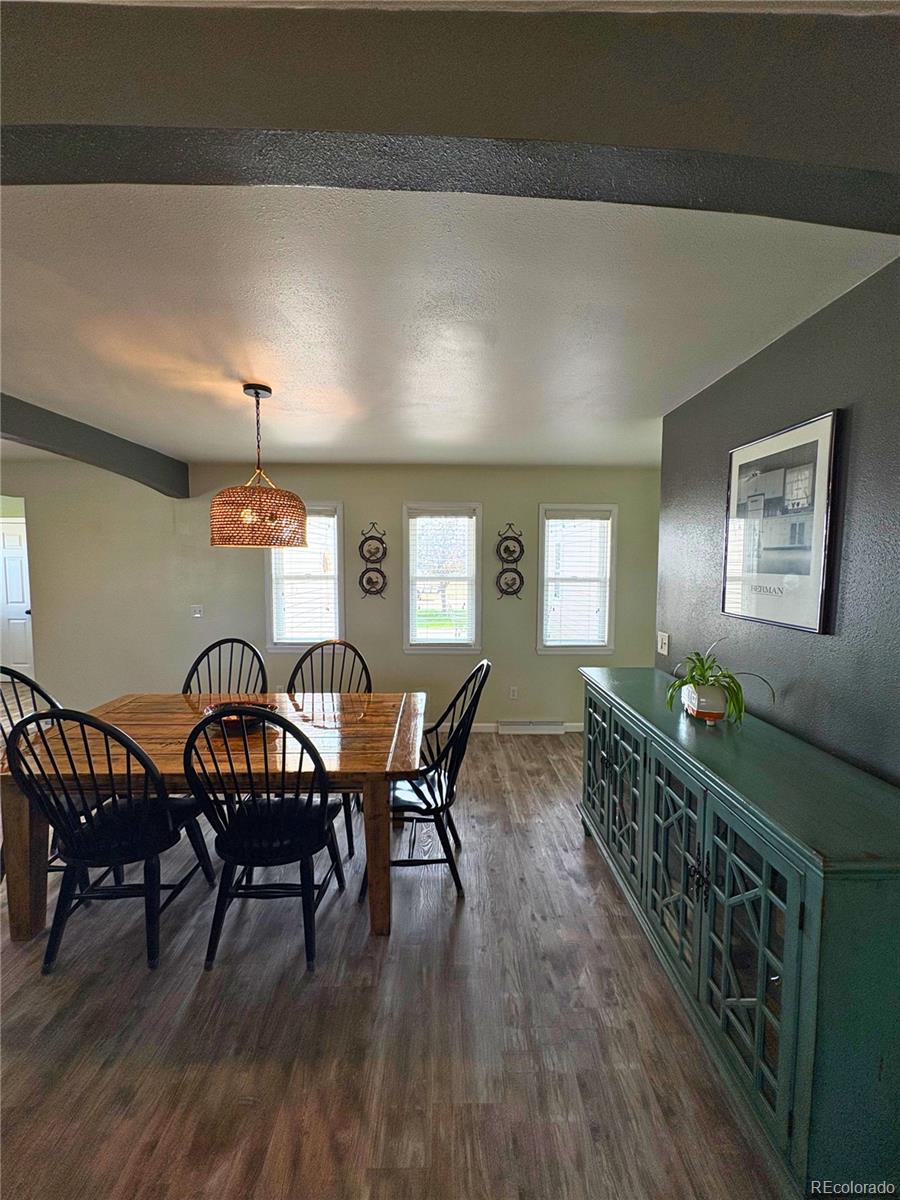 323 Fairview Street Otis, CO 80743 - Photo 14 of 38 a dining room with furniture a chandelier and wooden floor