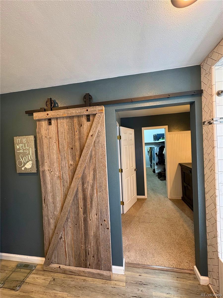 323 Fairview Street Otis, CO 80743 - Photo 17 of 38 a view of a hallway with wooden floor and stairs