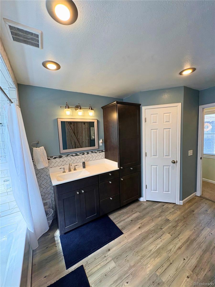 323 Fairview Street Otis, CO 80743 - Photo 19 of 38 a kitchen with a wooden floor and cabinets