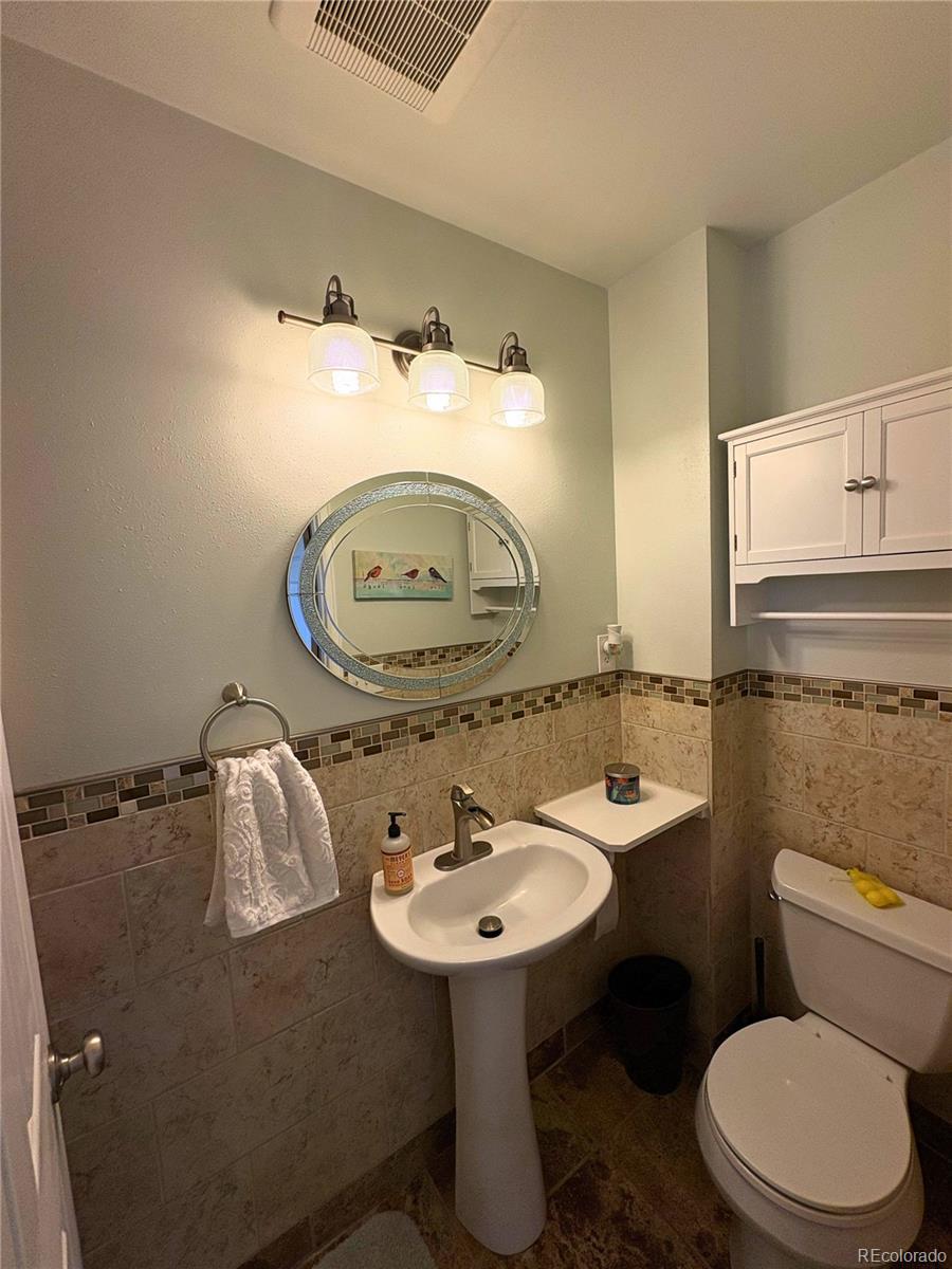 323 Fairview Street Otis, CO 80743 - Photo 24 of 38 a bathroom with a sink a mirror and a toilet