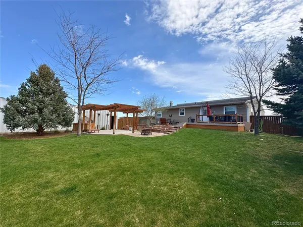 a view of a house with a big yard and large trees