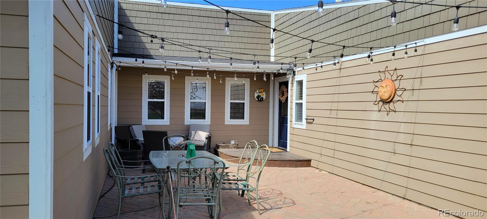 323 Fairview Street Otis, CO 80743 - Photo 6 of 38 a patio with table and chairs and potted plants