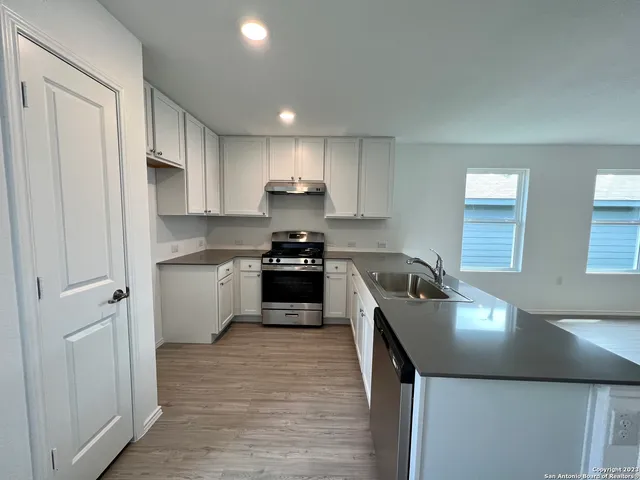 a kitchen with stainless steel appliances granite countertop a sink dishwasher stove and refrigerator
