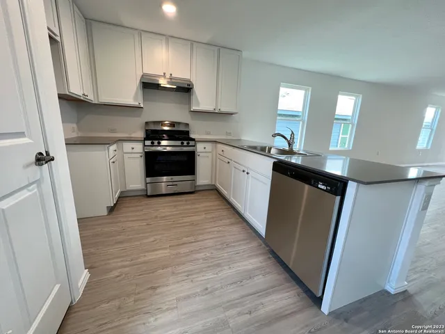 a kitchen with granite countertop white cabinets and black appliances