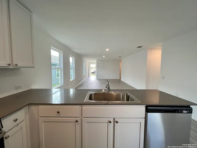 a kitchen with kitchen island granite countertop a sink a counter space and cabinets