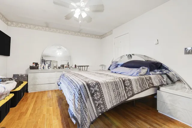 a spacious bedroom with a bed and a flat screen tv