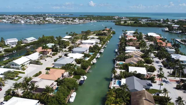 an aerial view of ocean and residential houses with outdoor space