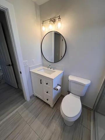 a bathroom with a toilet a sink and a mirror