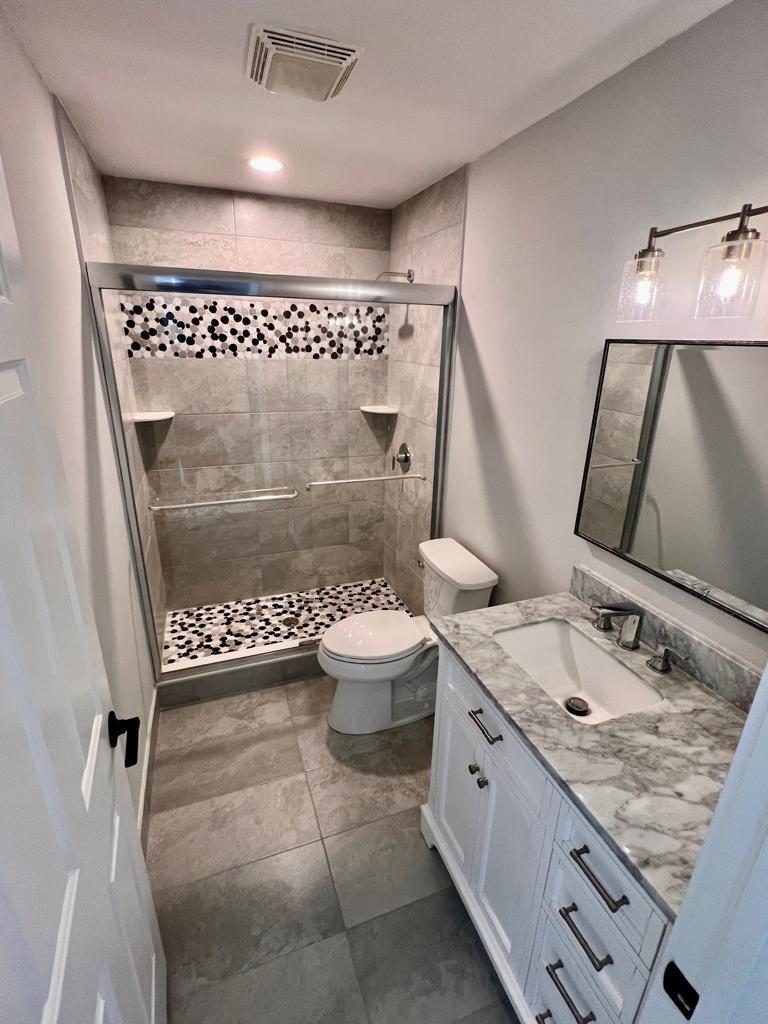 641 12th Street Key Colony Beach, FL 33051 - Photo 33 of 49 a spacious bathroom with a granite countertop sink a toilet a mirror and shower