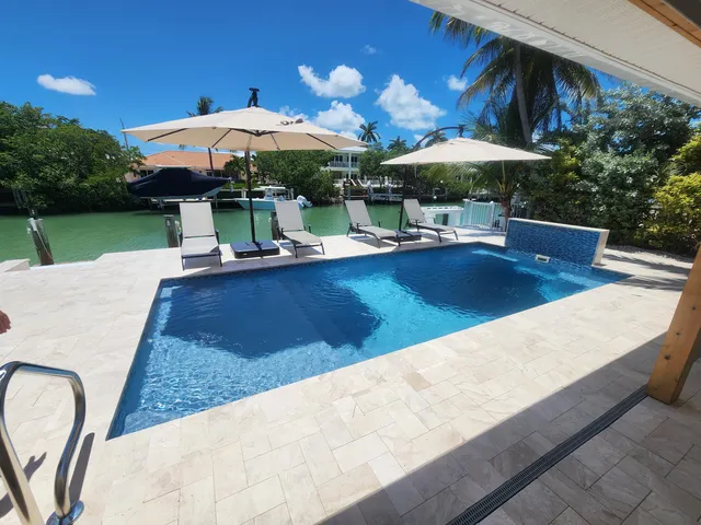 a view of house with swimming pool and outdoor seating