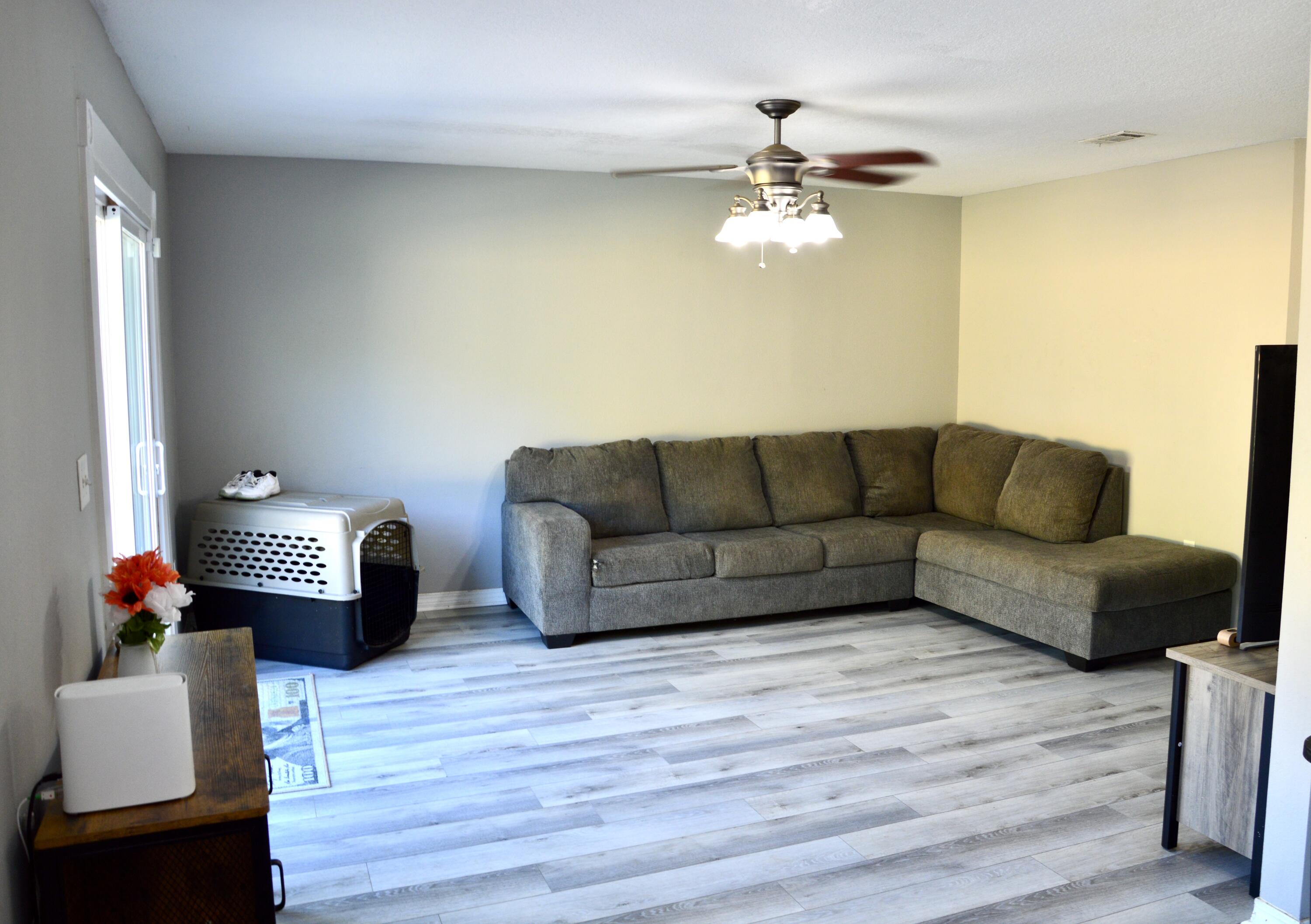 1705 North Pearl Street Crestview, FL 32536 - Photo 5 of 6 a living room with furniture a couch and a chandelier