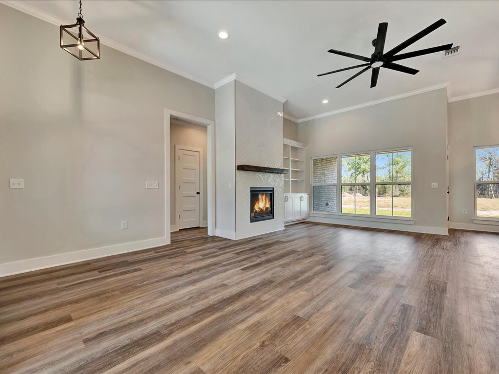 529 C C Road Diboll, TX 75941 - Photo 8 of 35 wooden floor in an empty room with a fireplace