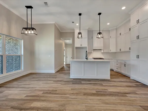 a view of kitchen and kitchen with stainless steel appliances granite countertop wooden floor
