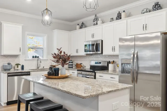 a kitchen with stainless steel appliances granite countertop a sink refrigerator and microwave