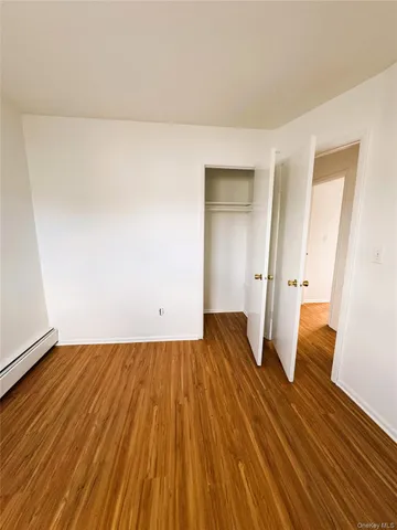 an empty room with wooden floor and a window
