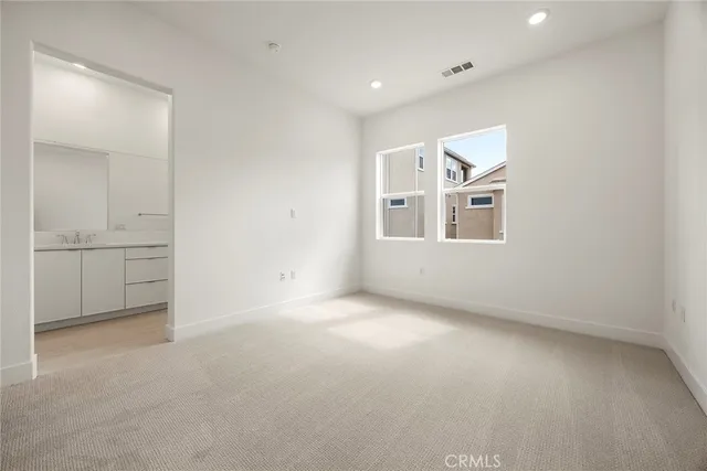 an empty room with windows and cabinet