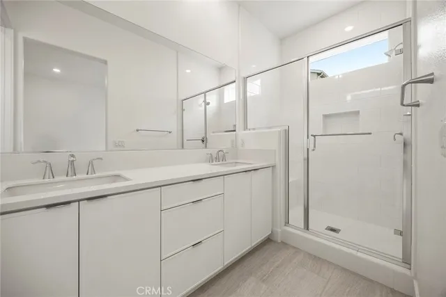 a bathroom with a shower sink and mirror