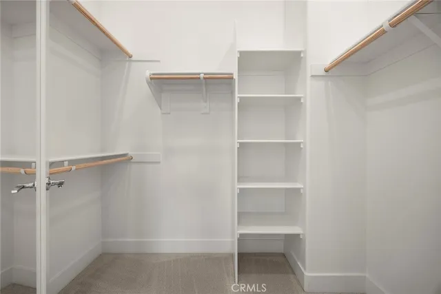 a view of walk in closet with empty racks