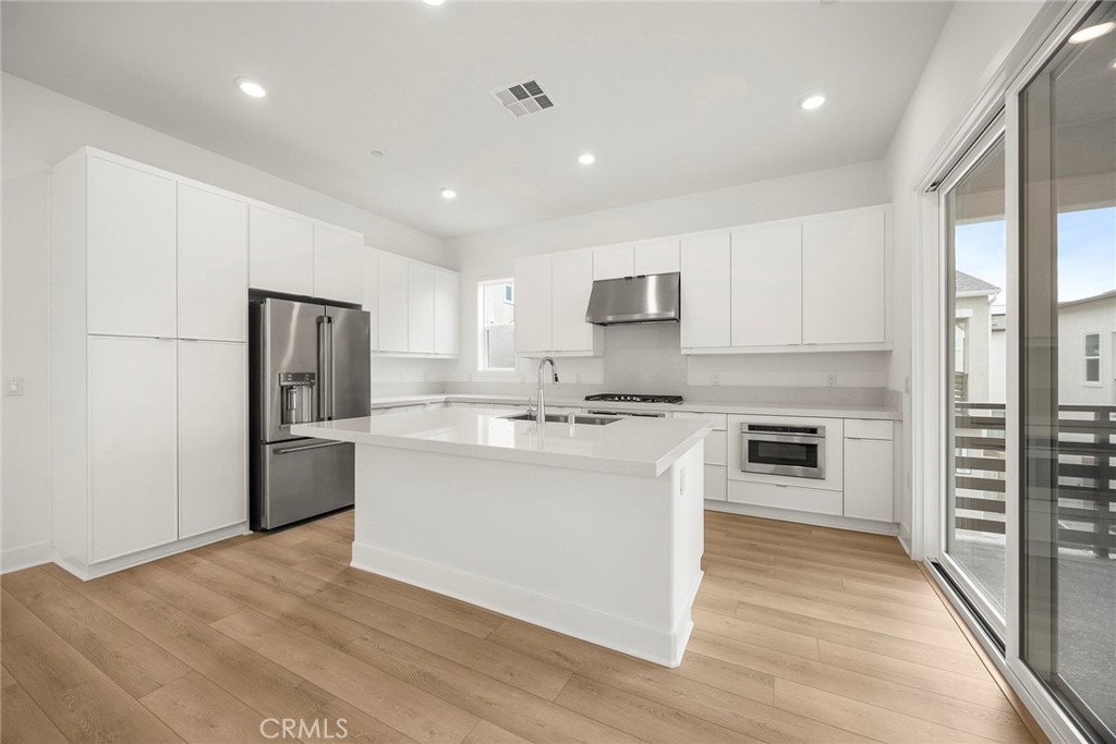 124 Tiffin Irvine, CA 92618 - Photo 8 of 26 a large kitchen with stainless steel appliances granite countertop a stove a sink and a refrigerator